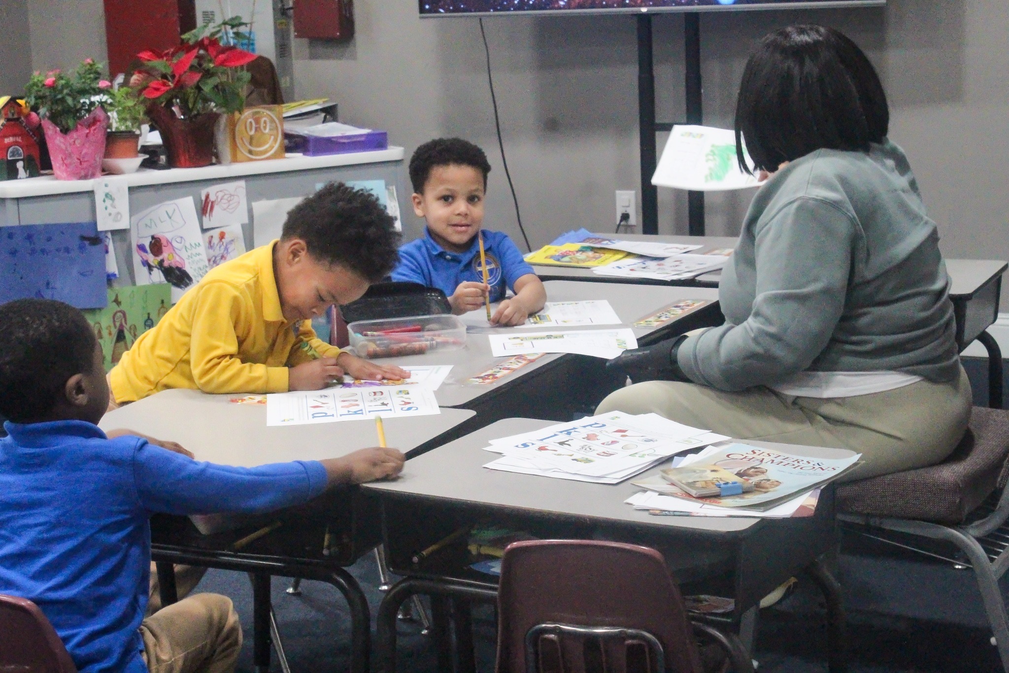 Teacher guiding children at a classroom table